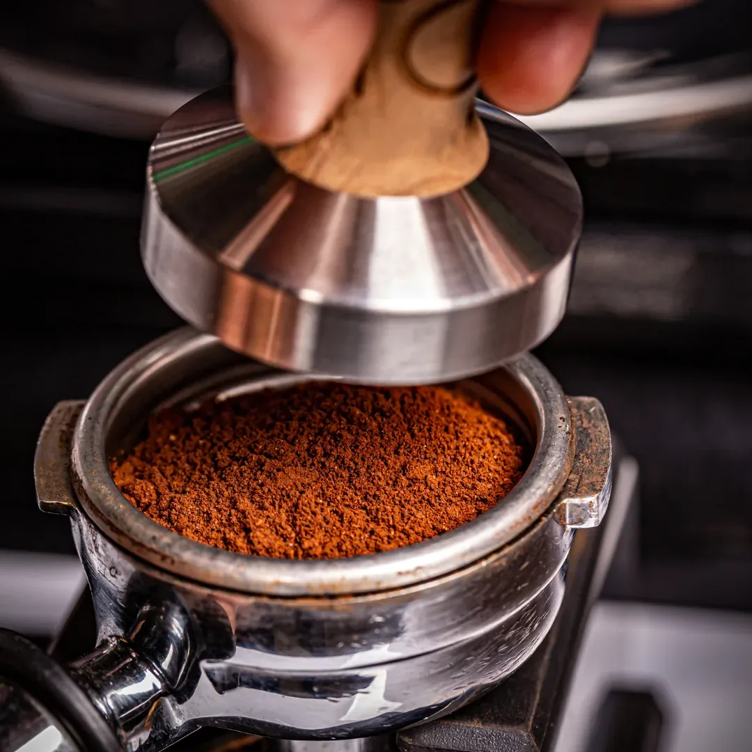 Barista tamping fresh coffee